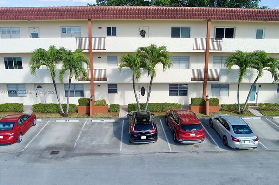 Front view of a multi-story building with parking spaces.