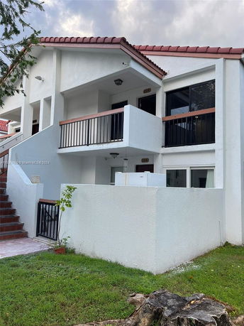 Front view of a two-story house with a staircase leading to the upper level.