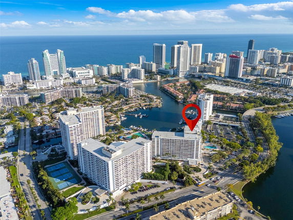 Aerial view of a cityscape with tall buildings near a body of water.