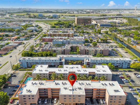 Aerial view of multiple residential buildings with roads and greenery in the surrounding area.