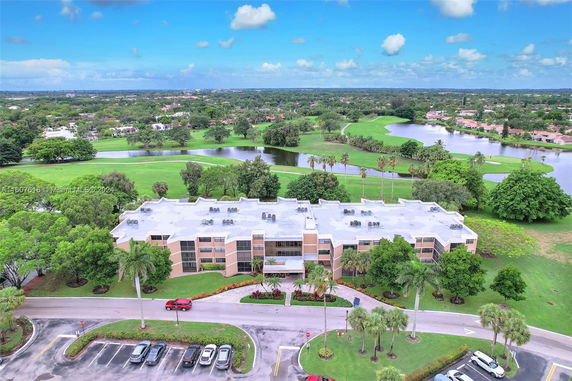 Aerial view of a large building surrounded by a green landscape and a golf course.