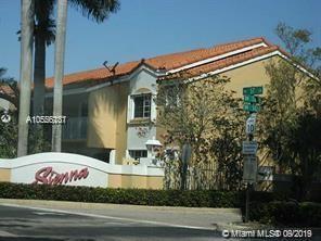 Front view of a two-story building with a red-tiled roof and a prominent sign at the entrance.