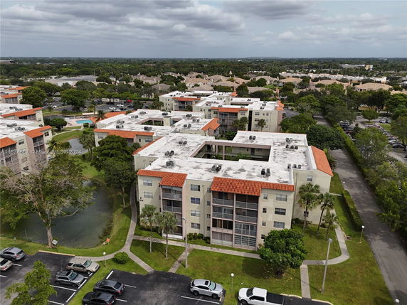 Aerial view of a building complex with flat rooftops featuring air conditioning units.