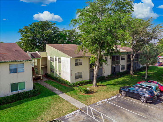 Front view of a multi-story residential building with parking.