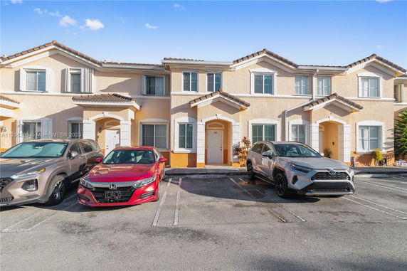 Front view of a two-story house with multiple units and parking area.