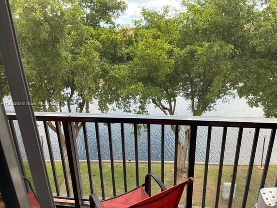 View from a balcony overlooking a body of water and trees.