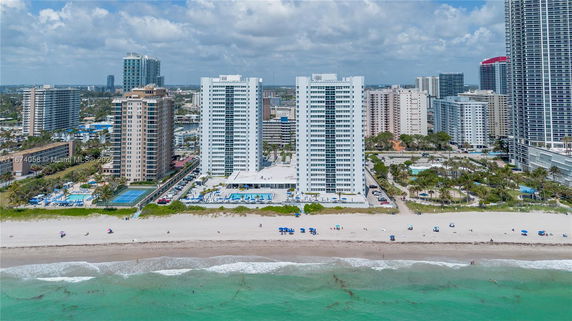 Aerial view of beachfront high-rise buildings with surrounding cityscape.