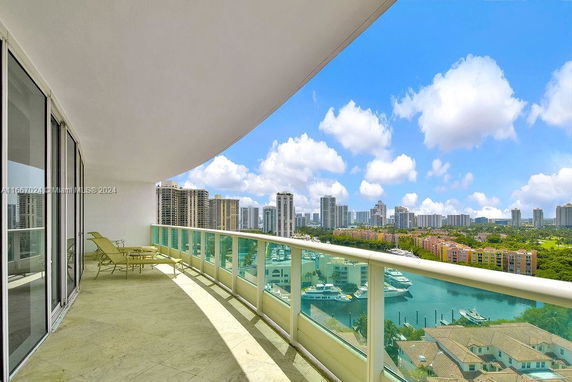 Panoramic view from a high-rise balcony with cityscape and marina.