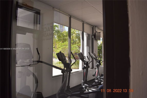 Interior view of a fitness area with exercise machines and large windows.