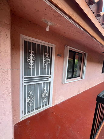 Front view of a building with a decorative white metal door and window.