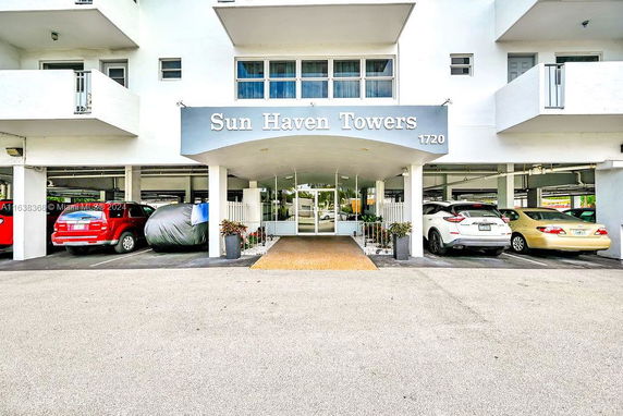 Outdoor covered parking area of Sun Haven Towers with multiple vehicles.
