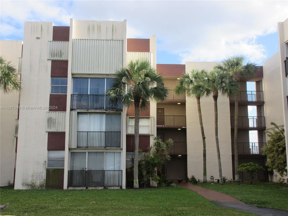 Front view of a multi-story apartment building with balconies.