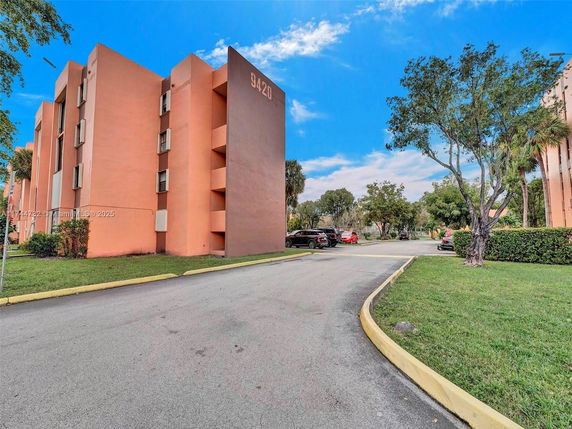 Front view of a multi-story apartment building with orange exterior.