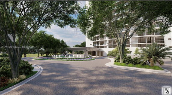 Front view of a multi-story building with a circular driveway and landscaping.