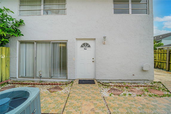 Front view of a two-story house with a door and sliding glass door.