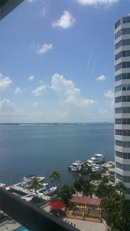 View of a waterfront area with boats docked near a building.