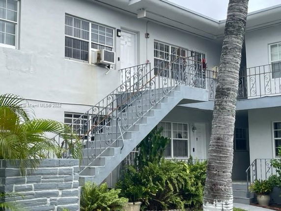 Front view of a two-story apartment building with outdoor stairs.