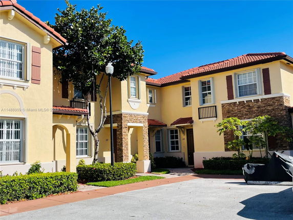 Front view of a two-story house with a red tiled roof and stone accents.