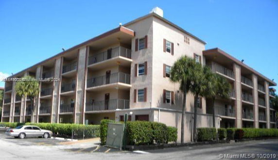 Front view of a four-story apartment building with balconies.