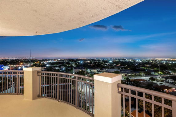 Panoramic view from a balcony overlooking a cityscape at night.