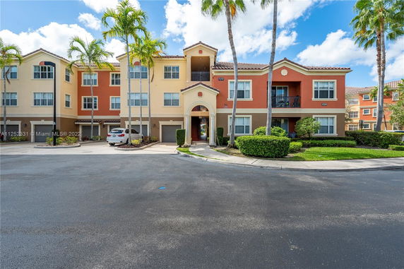 Front view of a multi-story residential building with a distinctive archway.
