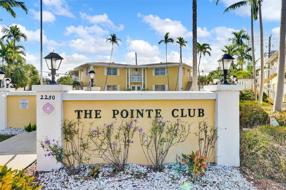 Front view of a multi-story residential building with a decorative entry sign.