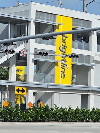 Front view of a modern building with a yellow accent panel.