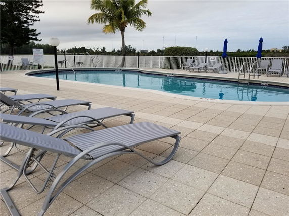 Outdoor area with a swimming pool and lounge chairs.