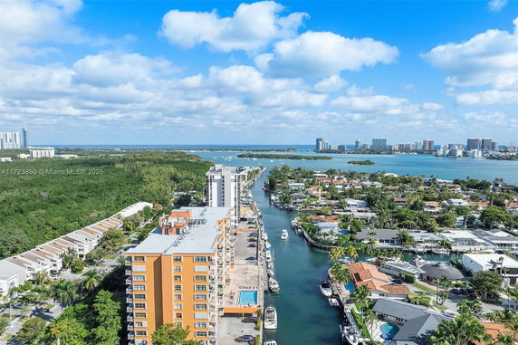 Panoramic view of a canal, buildings, and surrounding areas with a water body in the background.