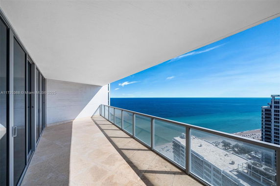Panoramic view from a building balcony overlooking the ocean.