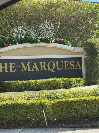 Sign with decorative elements and greenery.