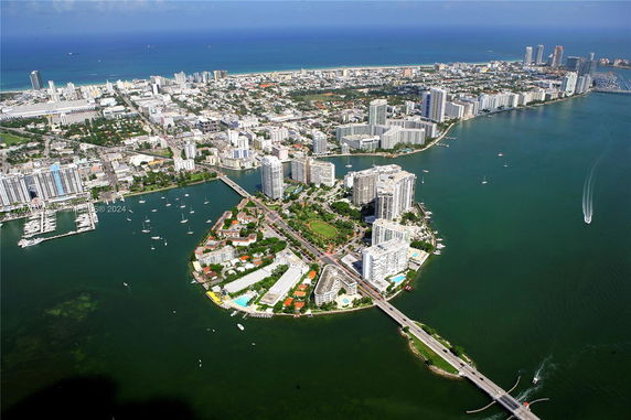 Aerial panoramic view of a coastal city with numerous buildings and a marina.
