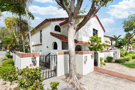 Front view of a two-story house with a gated entrance and Mediterranean architectural style.