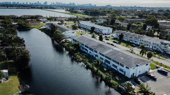 Aerial view of residential buildings by a water body with a cityscape in the background