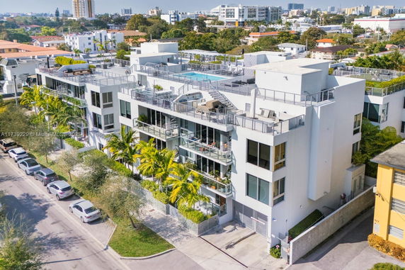 Front view of a modern multi-story apartment building with balconies.