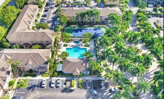 Aerial view of a residential complex with multiple buildings, a swimming pool, and parking area.