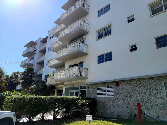 Front view of a multi-story apartment building with balconies.
