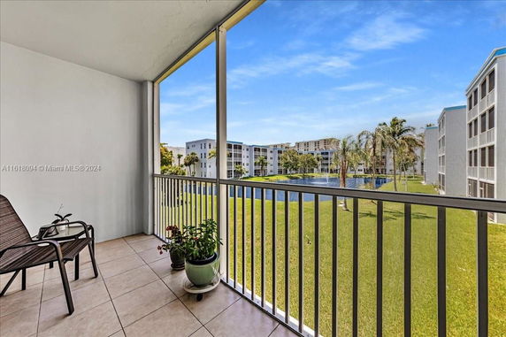 View from balcony showing surrounding apartment buildings and landscaped area.