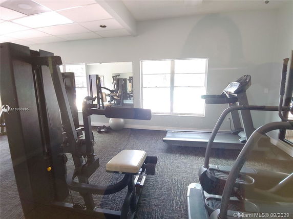 Indoor gym area with exercise equipment including a treadmill and weight machine.