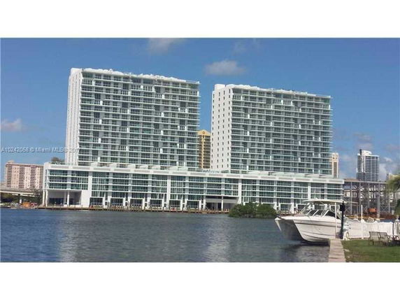 Front view of a modern high-rise building complex with a waterfront setting.