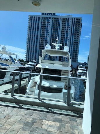Building with multiple floors overlooking a marina with yachts.