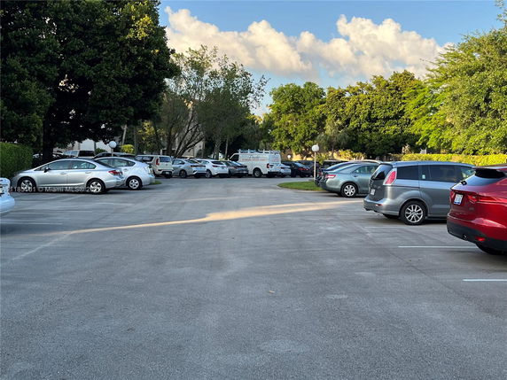 Outdoor parking area with several cars parked.