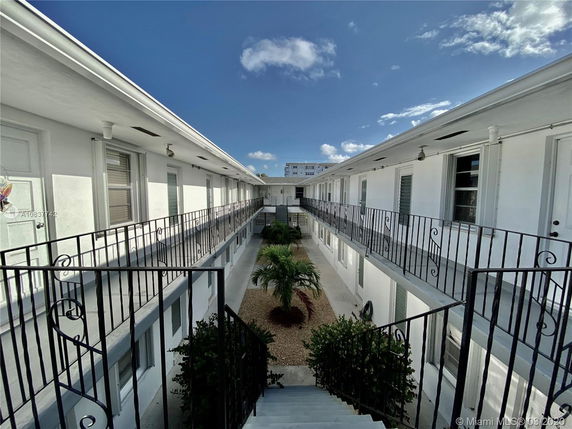 Front view of a two-story building with exterior corridors and a central courtyard.