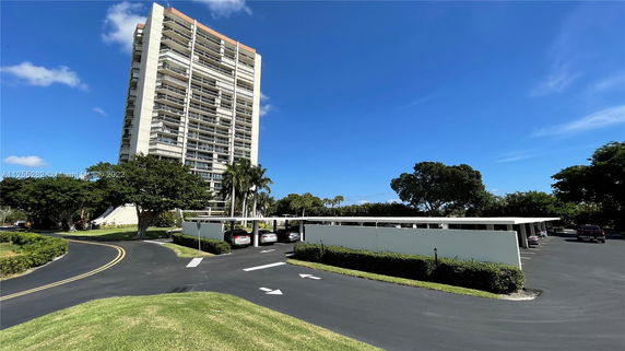 Outdoor parking area beside a tall residential building.