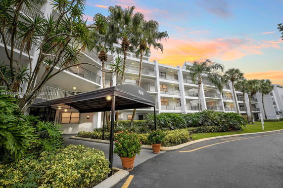Front view of a multi-story residential building with balconies and a covered entrance.