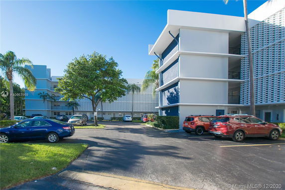 Outdoor parking area in front of a multi-story building.