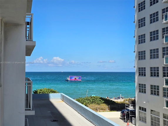 View from a building looking out towards the ocean with a visible ship on the water.