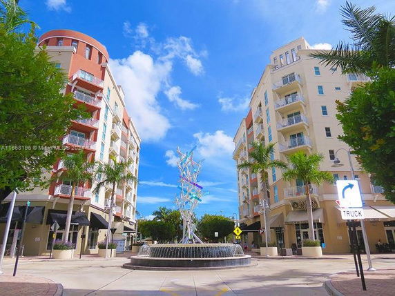 Front view of two multi-story apartment buildings with a central fountain.