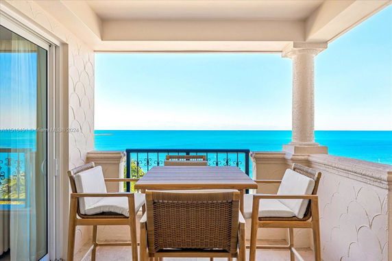 Outdoor seating area with ocean view on a balcony.