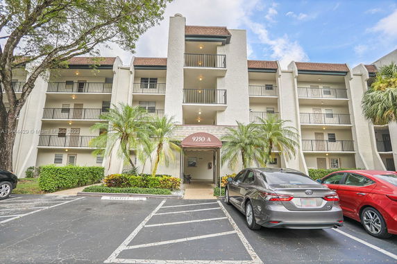 Front view of a multi-story residential building with balconies and an entrance.